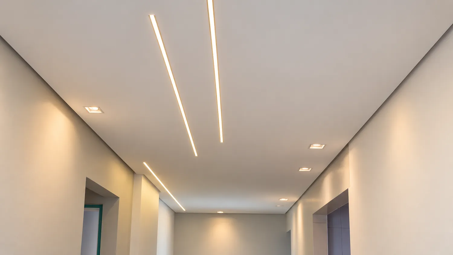 Corredor com forro de gesso, dois perfis de LED embutidos e spots quadrados